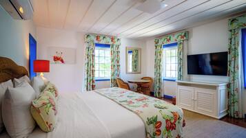 A bedroom with a bed, a TV, a desk, and a chair.