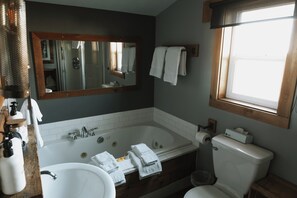 Un baño con bañera, lavabo e inodoro. Hay toallas y artículos de aseo en la encimera.