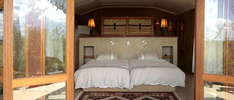 A double bed with a headboard, a patterned rug, and two bedside lamps.