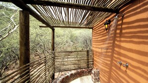 A rustic outdoor shower with a wooden frame and stone steps, surrounded by natural vegetation. - Waterberg Guest Farm (Otjiwarongo)