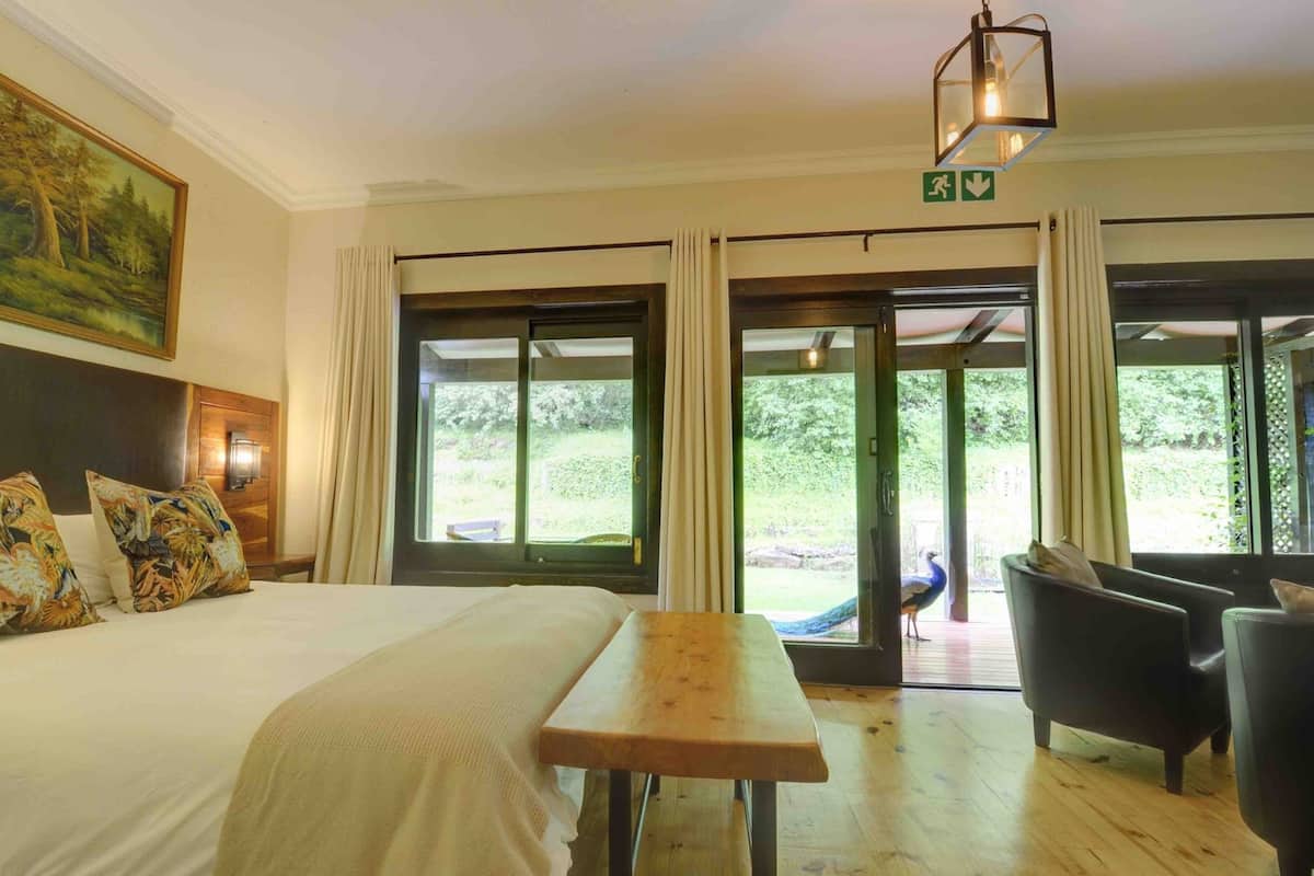 Habitación de hotel con una cama, una mesa de madera y vistas al exterior.