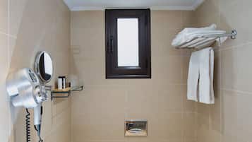 Ein Badezimmer mit Toilette, Fön, Spiegel und Handtuchhalter.