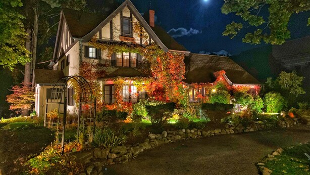 A large, two-story house with a steeply pitched roof, multiple windows, and a stone foundation. - Ivy Manor Inn Village Center (Bar Harbor)