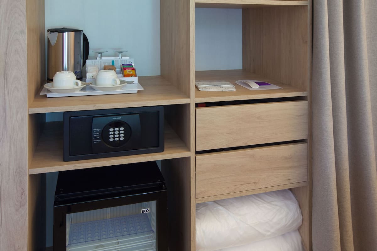 Une chambre d’hôtel équipée d’un mini-bar, d’une machine à café, d’un four à micro-ondes et d’un réfrigérateur.