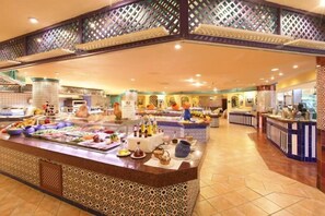 A buffet area with a variety of food items and beverages, a patterned floor, and a decorative ceiling. - Abora Buenaventura by Lopesan Hotels (San Bartolomé de Tirajana)