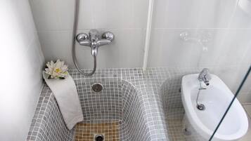 A bathroom with a bathtub, a shower, and a sink.
