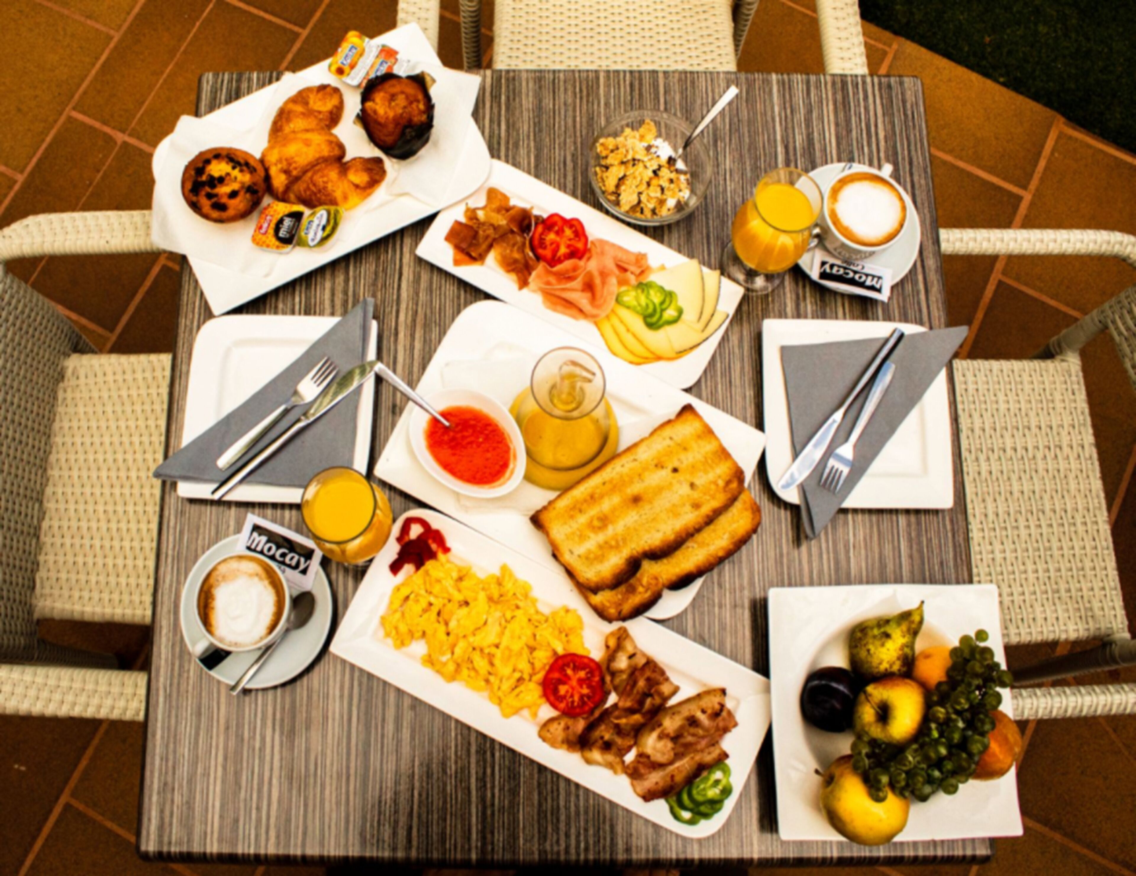 Buffet de l'esmorzar amb diverses platelles, incloent ous barrejats, torrades i fruita.