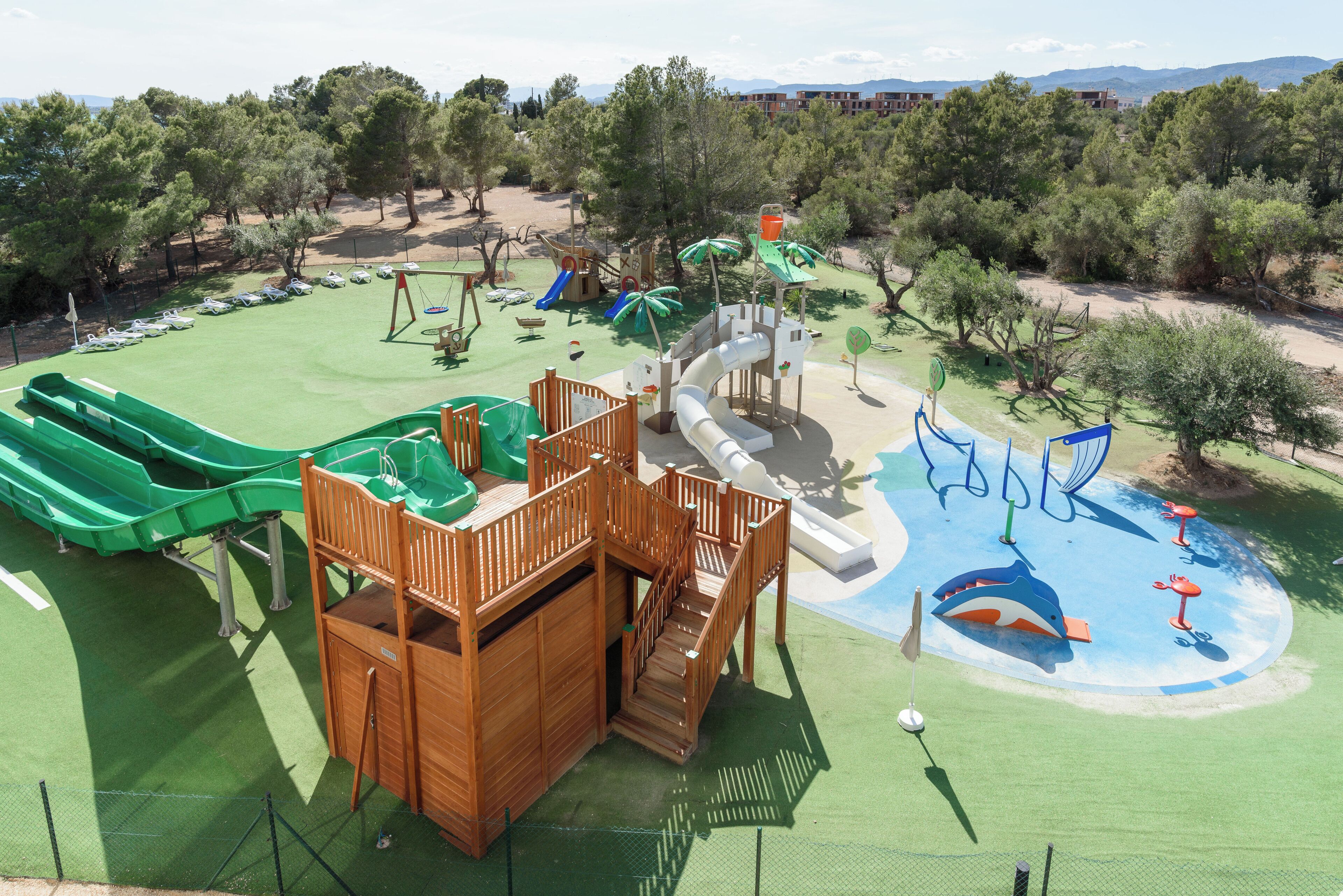 Un parque infantil con toboganes, columpios y una estructura para escalar.