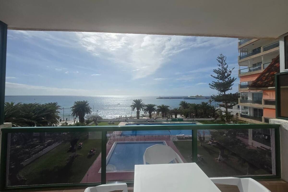A balcony with a view of the sea and a swimming pool.