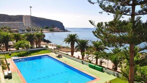 Une piscine avec vue sur la mer et un bâtiment en arrière-plan.