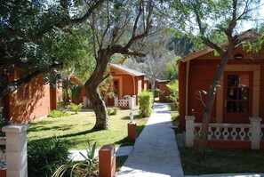 Uma fileira de casas de campo com telhados vermelhos e um calçadão entre elas.