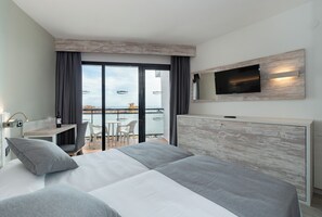 A modern hotel room with a large bed, a TV mounted on the wall, and a balcony with a view of the city. - Medplaya Bali (Benalmádena)