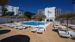 A hotel pool area with sun loungers, umbrellas, and a clear blue pool. - Medplaya Bali (Benalmádena)