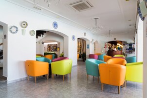 Un hall con asientos coloridos, platos decorativos y una zona de bar.