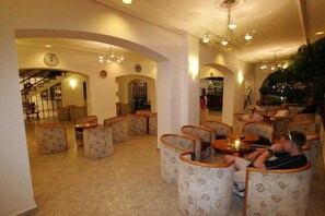 Un vestíbulo con una escalera, zona de estar y un bar.