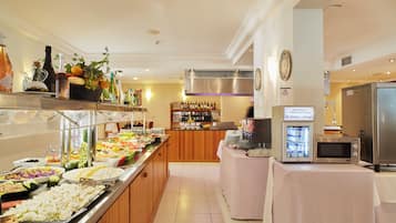 Uma área de buffet com diversas opções de comida e um refrigerador com bebidas.