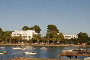 Escena costera con barcos, una playa y edificios.