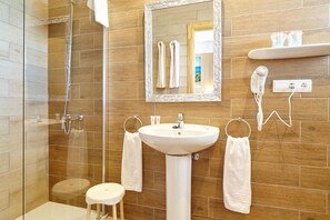A bathroom with a glass shower enclosure, a pedestal sink, a mirror, and a towel rack. - Hotel Ses Savines (Sant Antoni de Portmany)