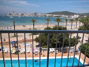 Zona de piscina con vista a la playa y al océano.