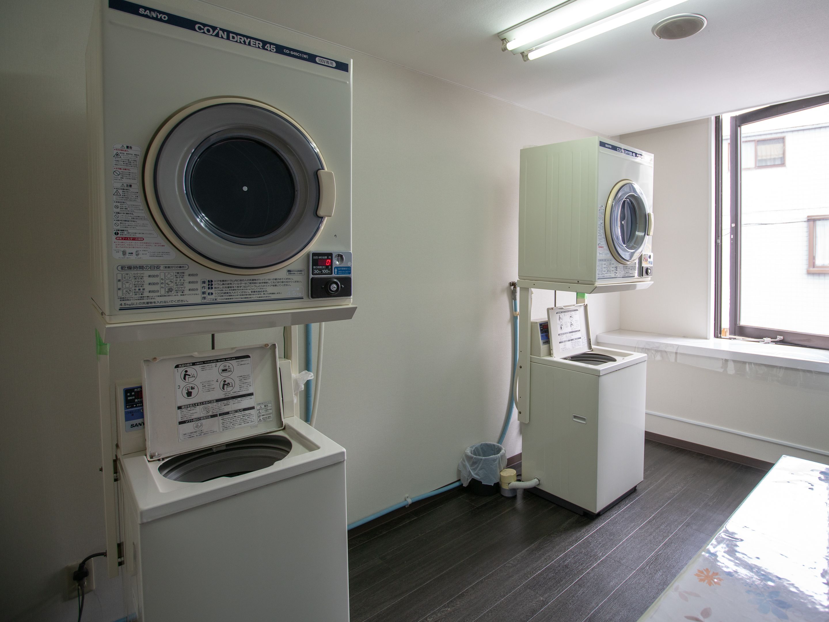A laundry room with two washing machines and a dryer.