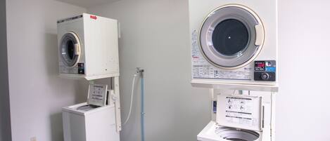 A laundry room with two stacked washers and a dryer.