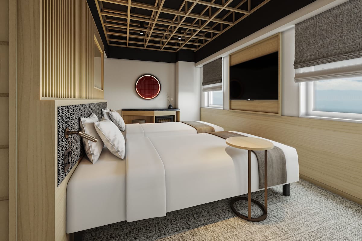 A modern bedroom with a large bed, a round wall clock, a small table, and a window with a view.