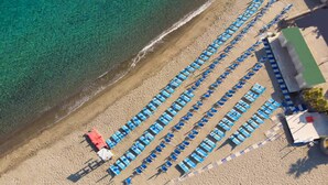 An aerial view of a beach with rows of blue and white sun loungers aligned parallel to the shoreline. - Hotel Terme Cristallo Palace  (Casamicciola Terme)