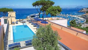 A rooftop pool with a clear view of the sea, a tree, and a marina. - Hotel Terme Cristallo Palace  (Casamicciola Terme)