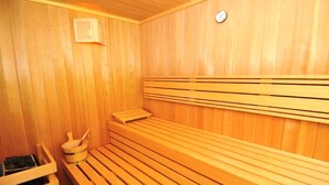 Un sauna en bois, doté de bancs et d’un petit appareil de chauffage.