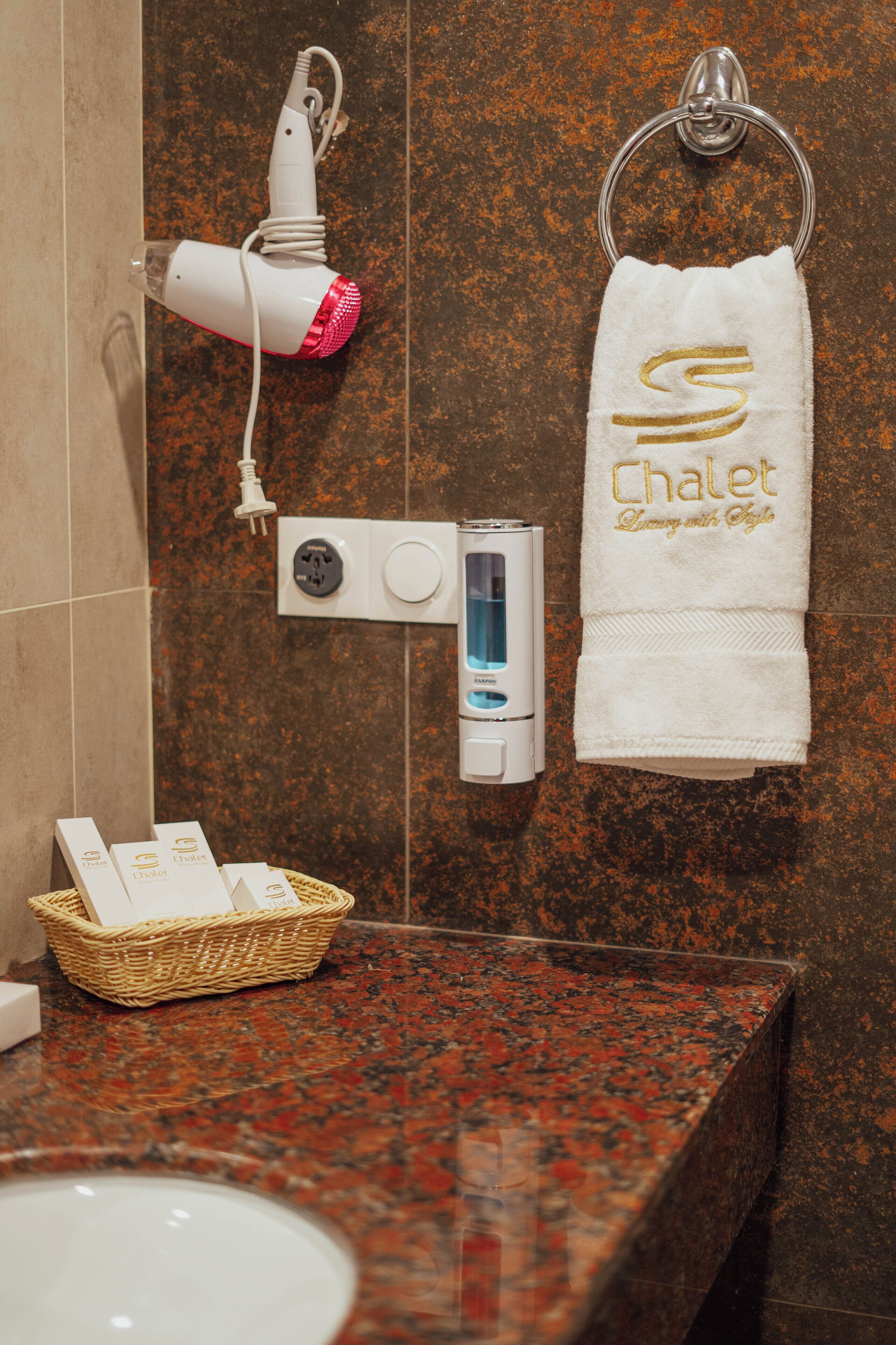 A bathroom with a hairdryer, towel, and toiletries on the counter.