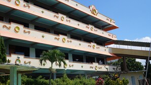 A multi-story building with balconies, a flat roof, and a decorative facade. - Hotel Surya Indah (Batu)