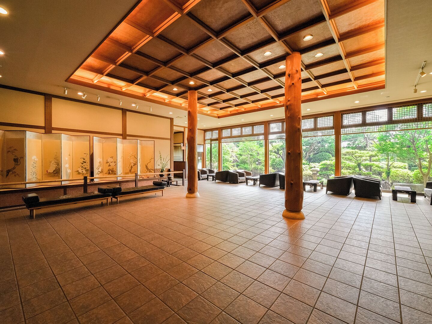 A spacious indoor area with a high ceiling, large windows, and traditional Japanese-style seating.