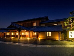 A traditional Japanese building with a covered entrance and a stone lantern.