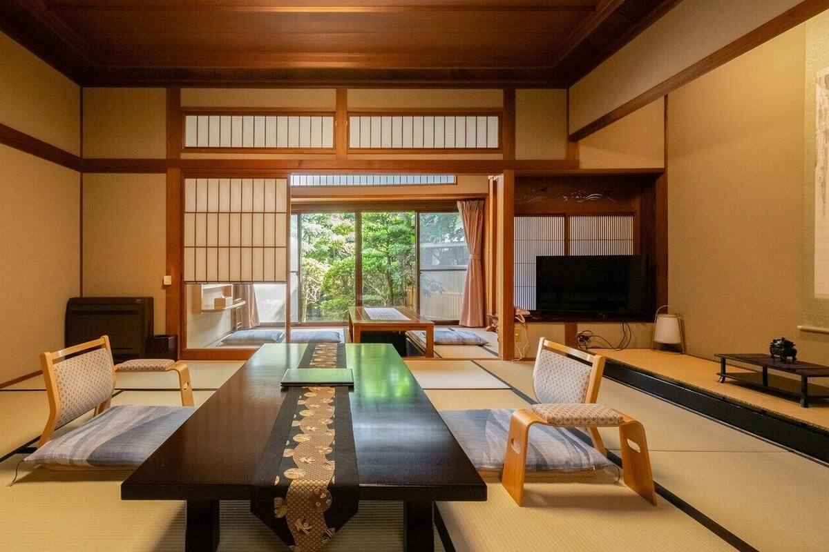 A traditional Japanese room with tatami flooring, a low table, and sliding doors.