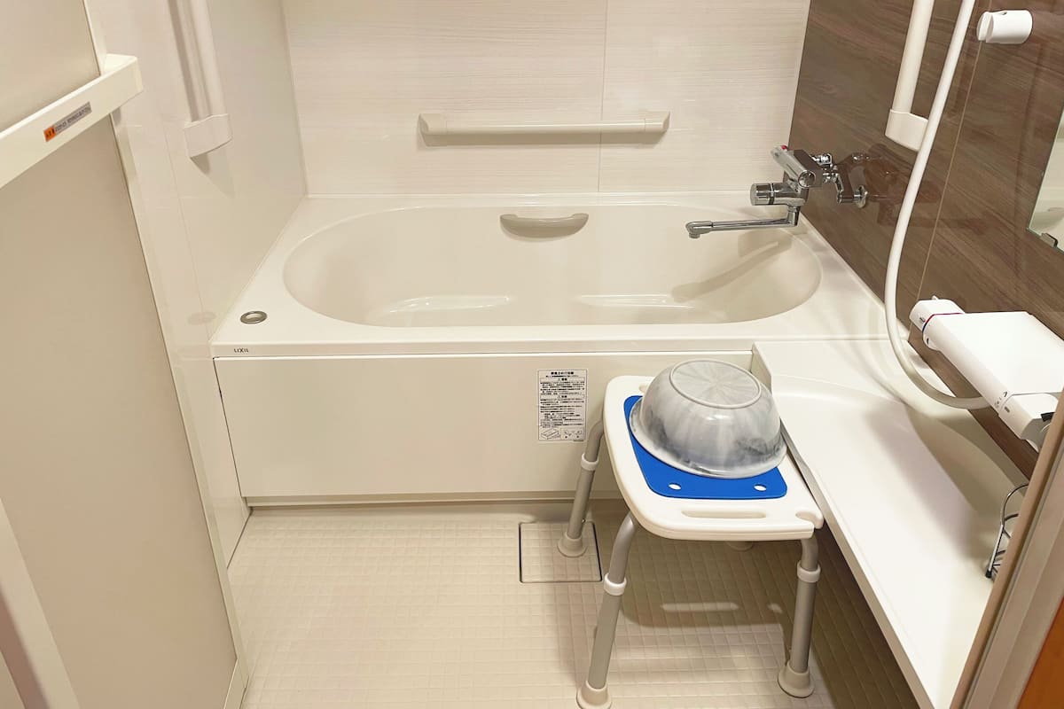A bathroom with a bathtub, a toilet, a sink, and a mirror.