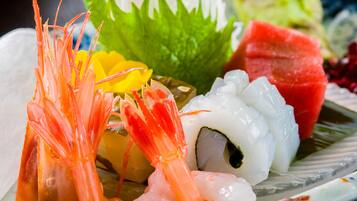A plate of sushi with shrimp, rice, and vegetables.
