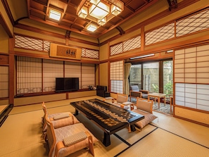 Une pièce de style japonais traditionnel, avec un sol recouvert de tatamis, une table basse et des paravents coulissants.