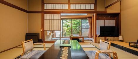 A traditional Japanese room with tatami flooring, a low table, and sliding doors.