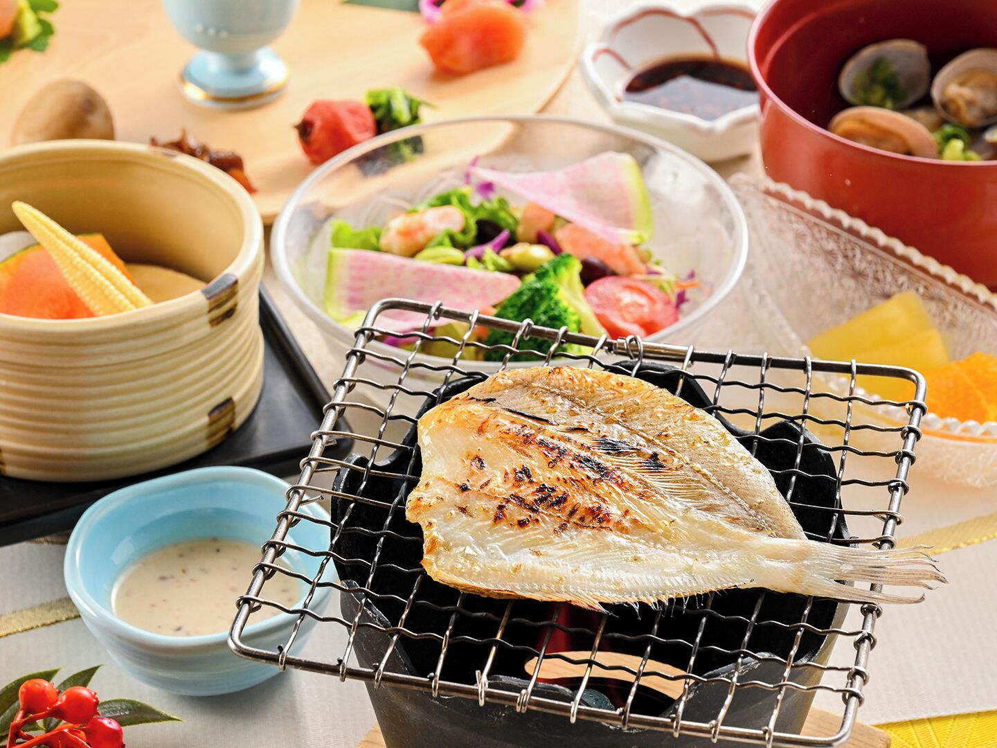 A grilled fish on a wire rack, surrounded by bowls of food and condiments.