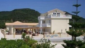 A two-story building with a balcony, a covered outdoor seating area, and a sign that reads "Tartine Garden". - Zantegarden (Zakynthos)