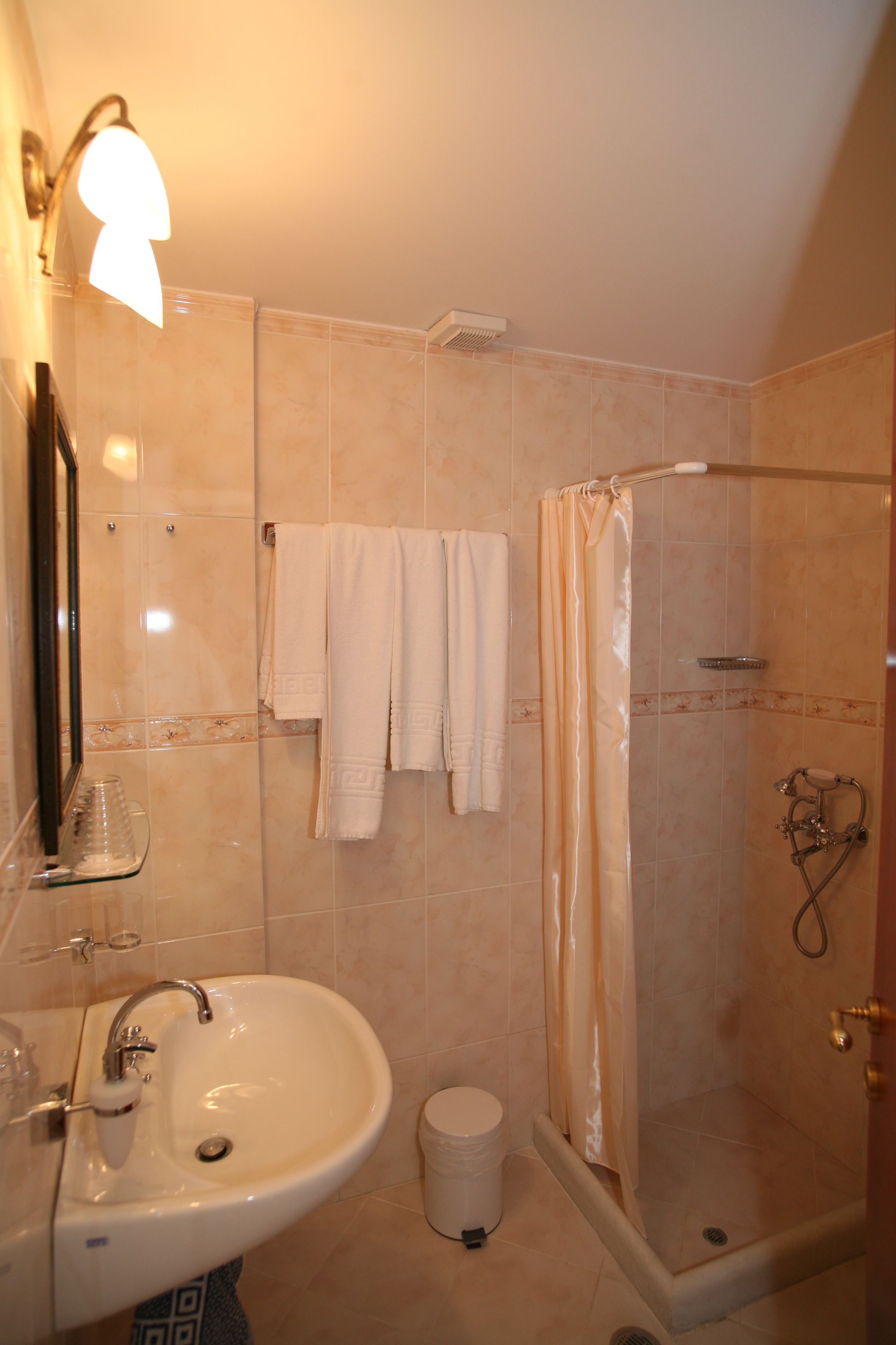 Baño con lavabo, espejo y ducha.