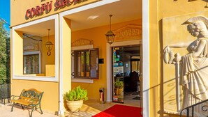A hotel entrance with a red carpet, a statue, and a sign reading "HOTEL CORFU SECRET". - Hotel Corfu Secret (Corfu)
