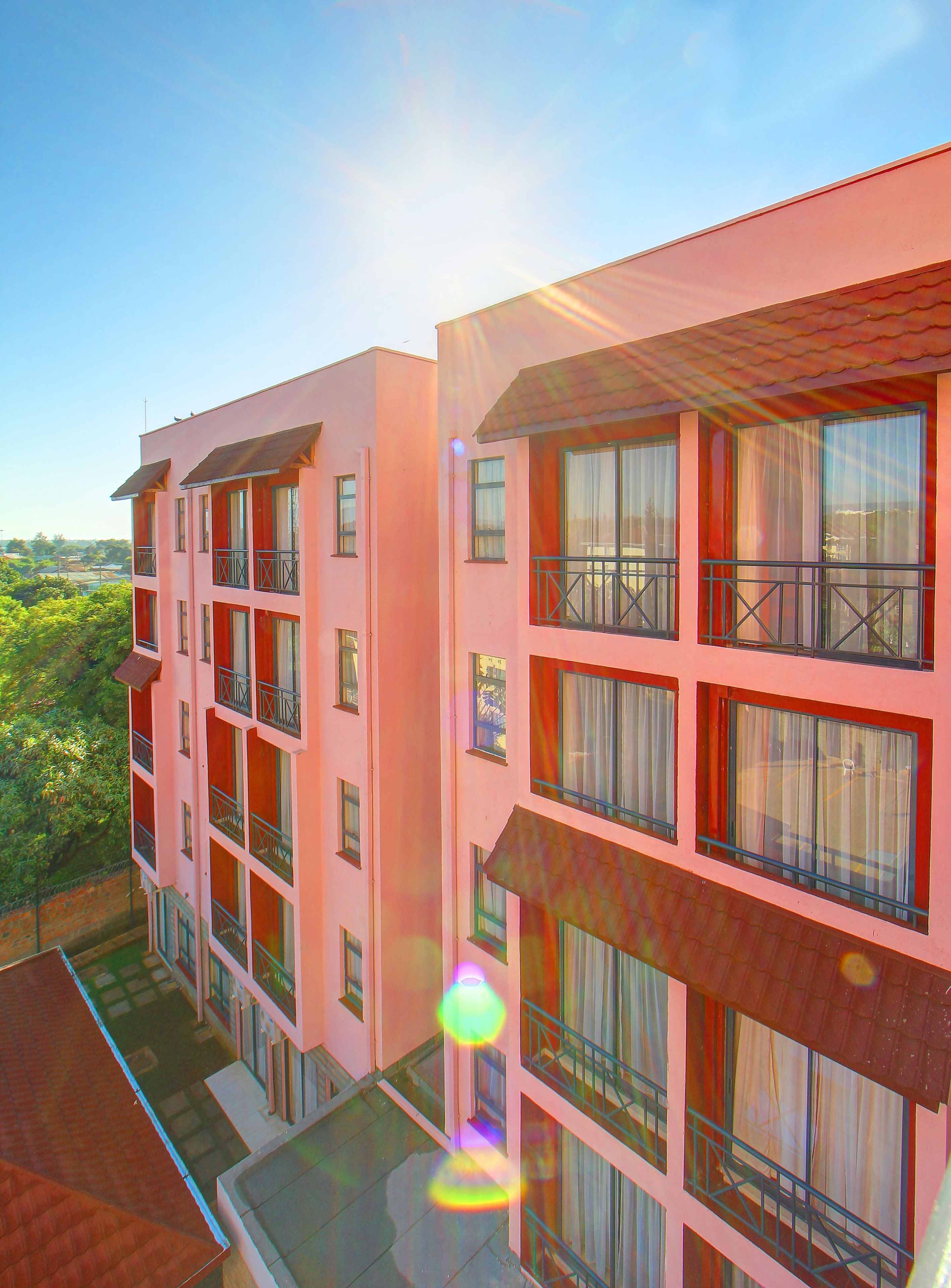 A multi-story building with balconies and large windows, likely a hotel or apartment complex.