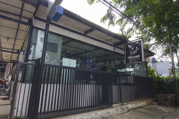 A café with a black metal fence, a glass window, and a sign that reads "Sari café & resto". - House of Arsonia Bougainvillea (Jakarta)