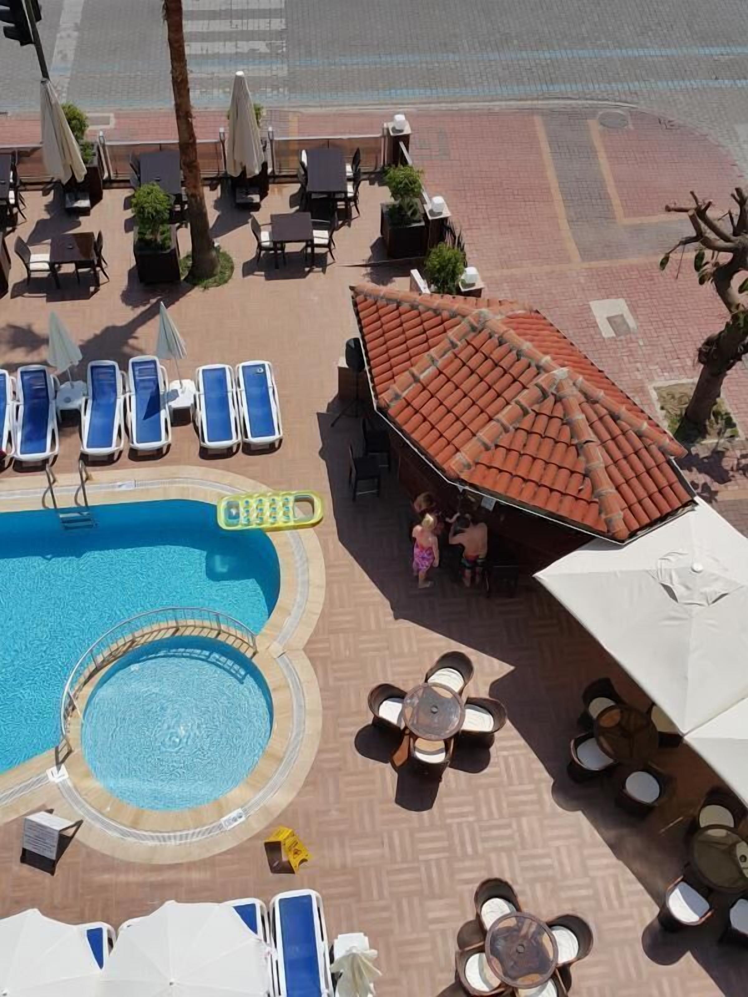 A rooftop pool area with lounge chairs, a small pool, and a covered seating area.