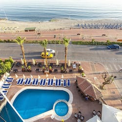 Una piscina al aire libre, sombrillas, sillones reclinables de piscina