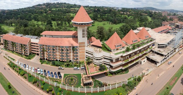 A hotel with multiple buildings, a central tower, and a parking area.
