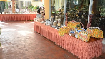 Ein reichhaltiges Buffet mit verschiedenen Speisen und Geschirr auf einem Tisch mit gemustertem Tischlein.