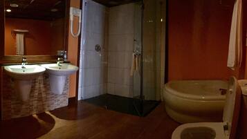 Une salle de bain avec deux lavabos, une douche et des toilettes.