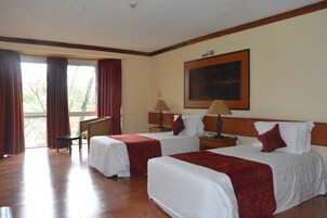 Una habitación de hotel con dos camas, un escritorio y una silla.